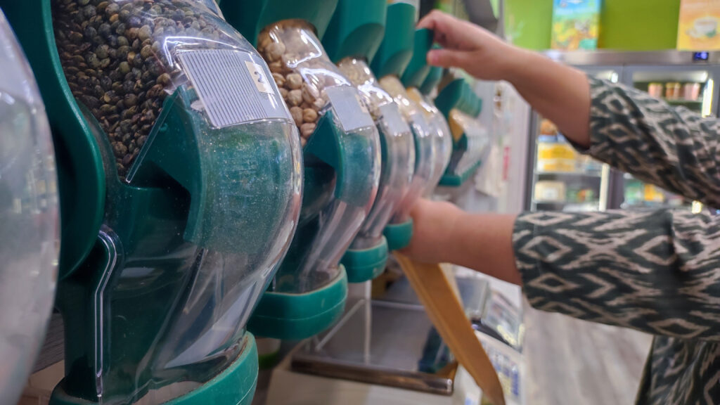 persona comprando cereales a granel llenando una bolsa de papel en herbolario Briona